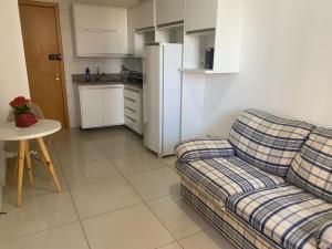 a living room with a couch and a table and a kitchen at Df Plaza Flat, Excelente in Águas Claras