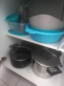 a kitchen shelf with bowls and plates and pans at fuerte blue in Costa Calma +10 photos