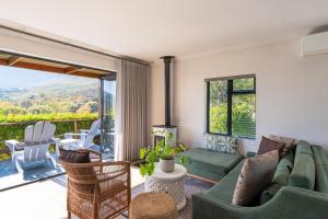 a living room with a couch and chairs and a balcony at Mont Angelis in Stellenbosch