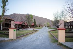 a road leading to a village with mountains in the background at Hotel El Nogalito in Cuatrociénegas de Carranza