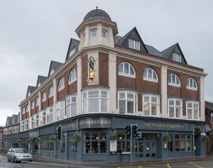 a large building with a clock on the front of it at Pilgrims Progress Wetherspoon in Bedford