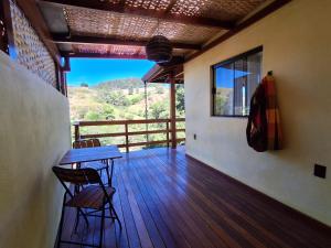 a room with a table and chairs on a deck at Chalé Davivi in Socorro