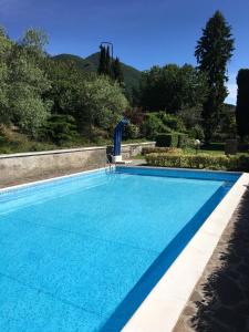 una piscina blu con una sedia in cortile di apartment Zagara - Gardone Riviera center a Gardone Riviera