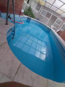 een zwembad met een blauwe tegelvloer bij Costa del sol Termas Ex Lucas III in Termas de Río Hondo