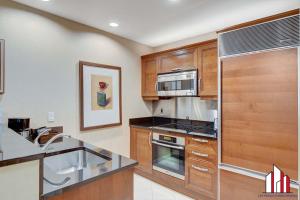 a kitchen with wooden cabinets and a stainless steel appliances at MGM Signature-15-802 1Br 2Ba F1 Pits View Balcony in Las Vegas