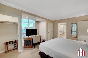 a bedroom with a bed and a desk and a television at MGM Signature-15-802 1Br 2Ba F1 Pits View Balcony in Las Vegas +49 photos