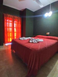een rood bed in een kamer met een rood raam bij Costa del sol Termas Ex Lucas III in Termas de Río Hondo
