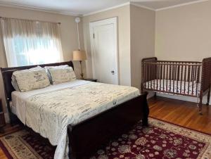 a bedroom with a bed and a crib in it at Big Historic Home Air Conditioning Parking in Niagara Falls