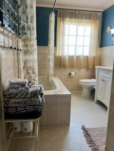 a bathroom with a tub and a toilet and a shower at Big Historic Home Air Conditioning Parking in Niagara Falls