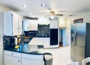 a kitchen with white cabinets and a stainless steel refrigerator at Niagara Falls Quiet Neighborhood Air Conditioning Parking in Niagara Falls