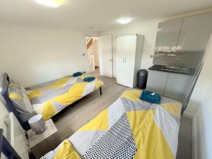 ミッチャムにあるSpacious 6-bedroom house in South London (Zone 4)のキッチン付きの部屋にベッドが2つあります