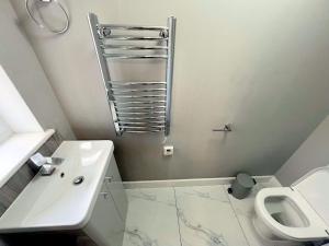 ミッチャムにあるSpacious 6-bedroom house in South London (Zone 4)の洗面台とトイレを備えた白いバスルーム
