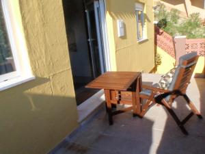 a wooden table and a chair on a patio at Varandas da Serra in Vila Franca de Xira