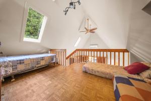 a bedroom with two beds and a ceiling fan at Le Repaire du Fleuve in Sainte-Croix