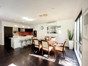a kitchen and dining room with a table and chairs at 4 Ensuites Patio Pool BBQ Billiards Media Room in Algester