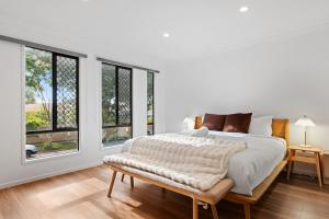 ブリスベンにあるSunnybank Hills Spacious 5BR Home for Familiesの白いベッドルーム(大型ベッド1台、窓付)