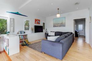 a living room with a couch and a tv at Perfect Family Home in Central Auckland in Auckland
