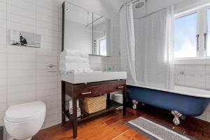 a bathroom with a tub and a sink and a toilet at Perfect Family Home in Central Auckland in Auckland +27 photos