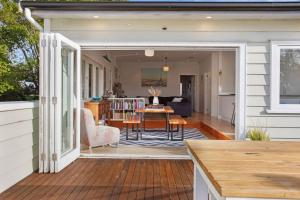 a screened in porch with a table and chairs on a house at Perfect Family Home in Central Auckland in Auckland