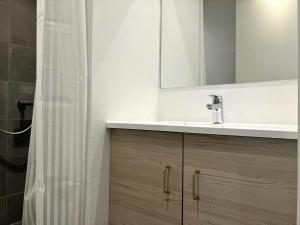 ein Badezimmer mit Waschbecken und Spiegel in der Unterkunft Central Studio for 1 in Fredericia