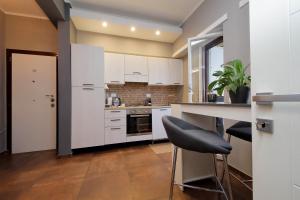 a kitchen with white cabinets and a table and chairs at Eur Trepini Luxury Loft in Rome