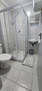 Un baño con ducha, inodoro y lavabo. en Grace Villas 2, en East London