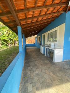 eine Außenküche mit blauen Wänden und einer Holzdecke in der Unterkunft sitio sonho verde in Serra Negra