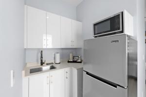 a white kitchen with a refrigerator and a microwave at Oasis Paradise at Cape Coral in Cape Coral +1 photo