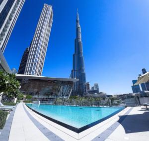 ドバイにあるGRANDE RESIDENCES with a direct Burj Khalifa view and Private Fountain Show with DXB AIRPORT VIP Shuttleのブルジュ・ハリファの景色を望む市街のプールを望めます。