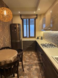 a kitchen with a refrigerator and a table with chairs at Kobuleti apartment in Kobuleti