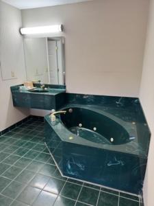 a bathroom with a black tub and a sink at Southern Lodge - Orangeburg 601 in Orangeburg