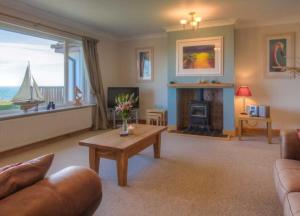 Whiting BayにあるSpacious holiday home with stunning sea viewsのリビングルーム(ソファ、暖炉付きテーブル付)
