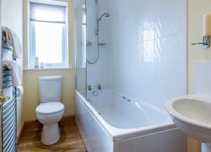 Whiting BayにあるSpacious holiday home with stunning sea viewsのトイレと洗面台を備えた白いバスルーム +18枚の写真