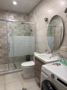 a bathroom with a toilet and a shower and a sink at Kobuleti apartment in Kobuleti +22 photos