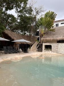 a swimming pool at a resort with chairs and a building at Hotel Xbalamqué Boutique & Spa in Cancún