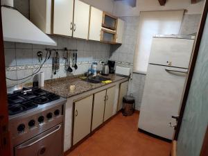 a kitchen with a stove and a white refrigerator at La Posada de Buda in Malargüe