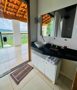 un baño con lavabo y espejo en Estância do Sol, en Pirenópolis