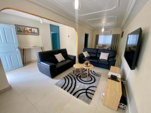 a living room with a couch and a table at Villa M Douala Maison 3 Chambres Makepe in Douala