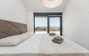 a white bedroom with a bed with two towels on it at Cozy Home In Turanj With Sauna in Turanj