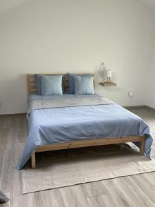 a bedroom with a large bed with blue pillows at Oeste Garden Suites in Caldas da Rainha