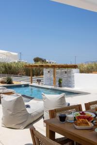 a table with food on it next to a swimming pool at calmare collection hotel in Plaka