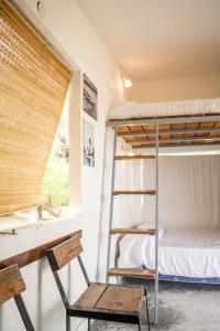 a bunk bed in a room with a chair and a window at Cabañas El Yaguaron in La Porteña