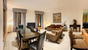 a living room with a table and chairs and a couch at Luxury Apartment, Panoramic Mountain Views, 5 Star Spa Facilities - 3 Bedroom in Chateau-d'Oex