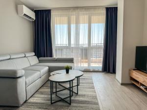 a living room with a couch and a table at 1BR Apartment with Panoramic View Balcony and Designated Parking Space in Plovdiv