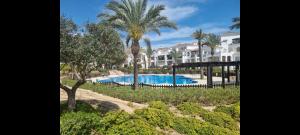 a resort with a swimming pool and palm trees at Beautiful views lake golf house in Roldán