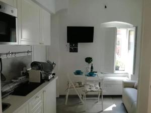 a kitchen with white cabinets and a table in a room at Cozy studio Monterosso al Mare 22 m² with air conditioning in Monterosso al Mare