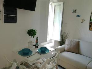 a white living room with a table and a couch at Cozy studio Monterosso al Mare 22 m² with air conditioning in Monterosso al Mare