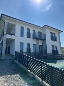 a white building with a fence in front of it at Casa Miron in Dezmir