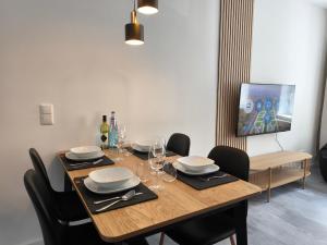 a dining room table with chairs and a television at maremar - Apartments am Ferberturm - Luxus Boxspringbett - Küche - Arbeitsplatz - WLAN in Gera