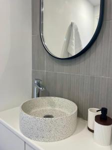 Un lavabo de baño con un fregadero redondo de granito. en Appartement Gare 2 Personnes, en Le Mans